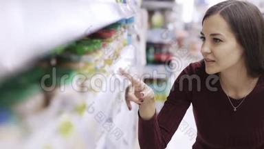 女人的肖像看着<strong>价格标</strong>签，在<strong>超市</strong>里寻找货架上的产品